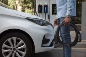 vista lateral hombre sujetando cable coche Curso de cargadores eléctricos Las Palmas de Gran Canaria